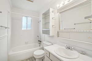 Full bathroom with shower / tub combination, toilet, vanity, and ornamental molding