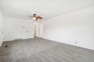 Unfurnished room featuring carpet and ceiling fan