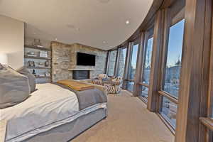 Bedroom with light carpet and a fireplace