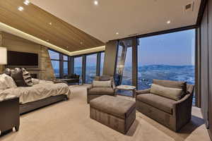 Bedroom with a mountain view, light colored carpet, and a wall of windows