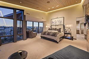 Bedroom featuring a towering ceiling, light colored carpet, and wooden ceiling