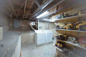 Basement featuring electric panel, washer and dryer, and a workshop area