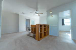 Hallway with light colored carpet and ornamental molding