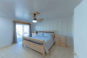 Primary Bedroom with access to outside, ceiling fan, and light carpet