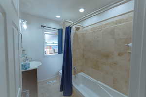 Full bathroom with tile patterned flooring, vanity, toilet, and shower / bath combo with shower curtain