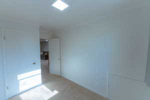 Empty room with light colored carpet and ornamental molding