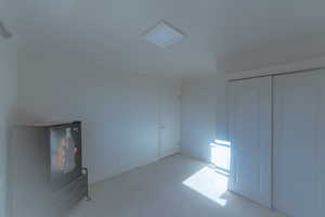 Unfurnished bedroom featuring ornamental molding, light carpet, and a closet