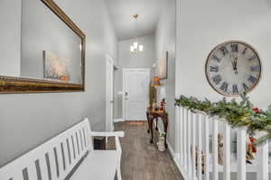 Hallway featuring a chandelier, dark hardwood / wood-style floors, and high vaulted ceiling