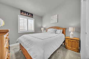 Carpeted bedroom featuring lofted ceiling