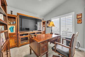 Carpeted office space with vaulted ceiling