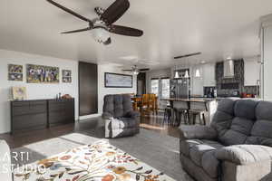 Living room with ceiling fan and dark wood-type flooring