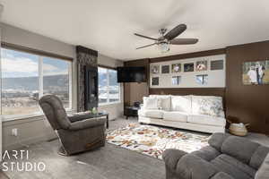 Living room with a mountain view, carpet floors, and ceiling fan