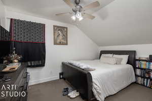 Bedroom featuring ceiling fan, carpet, and lofted ceiling