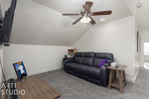 Living room featuring ceiling fan, light colored carpet, and vaulted ceiling