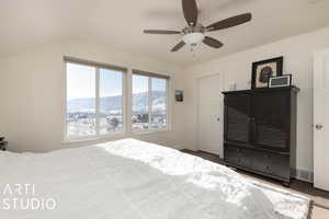 Bedroom featuring dark colored carpet, a mountain view, ceiling fan, and vaulted ceiling