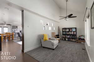 Sitting room featuring ceiling fan, high vaulted ceiling, and dark hardwood / wood-style floors