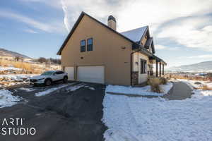 Snow covered property featuring a mountain view and a garage