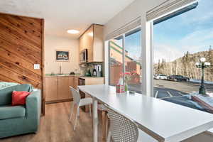 Dining room featuring wooden walls, sink, and light hardwood / wood-style floors