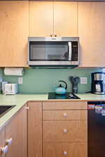 Kitchen with light brown cabinets and black appliances