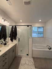 Bathroom with vanity, shower with separate bathtub, and a textured ceiling