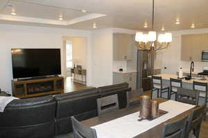 Dining area featuring dark hardwood / wood-style floors, an inviting chandelier, and a tray ceiling