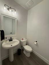 Bathroom featuring wood-type flooring and toilet