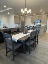 Dining area with hardwood / wood-style flooring and a notable chandelier