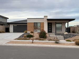 View of front of property featuring covered porch and a garage