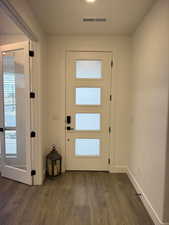 Doorway to outside with dark wood-type flooring