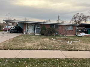 Ranch-style house with a carport and a front lawn