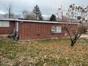 View of property exterior with a lawn and a mountain view