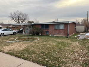 Ranch-style house with a carport and a front lawn