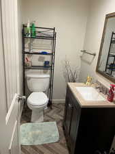 Bathroom featuring parquet flooring, vanity, and toilet