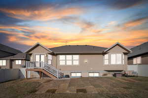 Back house at dusk with a lawn