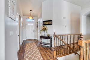 Foyer entrance featuring dark hardwood / wood-style flooring and vaulted ceiling