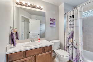 Full bathroom featuring vanity, shower / tub combo, and toilet