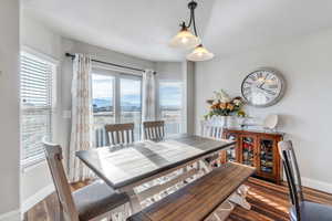 Dining area with a wealth of natural light, a mountain view, and dark wood-type flooring