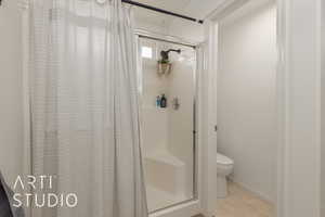 Bathroom with tile patterned floors, a shower with curtain, and toilet