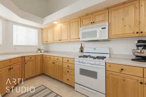 Kitchen featuring white appliances and sink