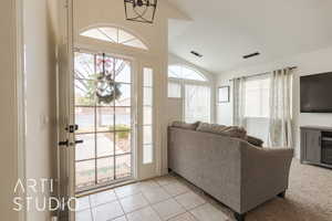 Tiled living room with an inviting chandelier and vaulted ceiling