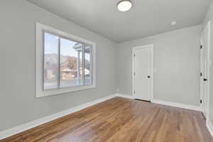 Unfurnished bedroom featuring a textured ceiling and dark hardwood / wood-style flooring