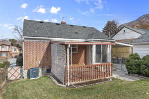 Back of house featuring central air condition unit and a yard