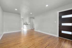 Unfurnished living room with a healthy amount of sunlight and light wood-type flooring