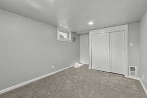 Unfurnished bedroom featuring light carpet and a closet