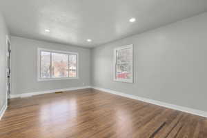 Unfurnished room featuring hardwood / wood-style floors and a textured ceiling