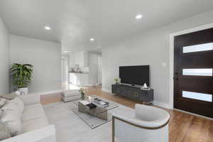 Virtually staged living room featuring a healthy amount of sunlight and light hardwood / wood-style flooring