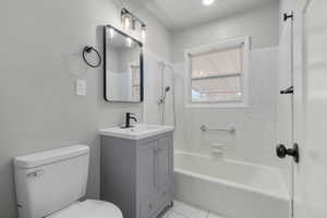 Full bathroom featuring tile patterned flooring, vanity, toilet, and tiled shower / bath