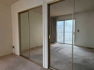 View of closet (takes up the whole wall) in the main bedroom, with doors to the patio.