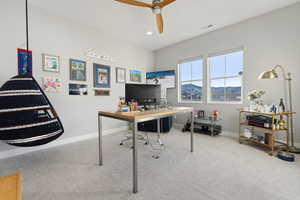 Carpeted home office featuring ceiling fan