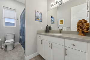 Bathroom featuring tile patterned floors, vanity, and toilet